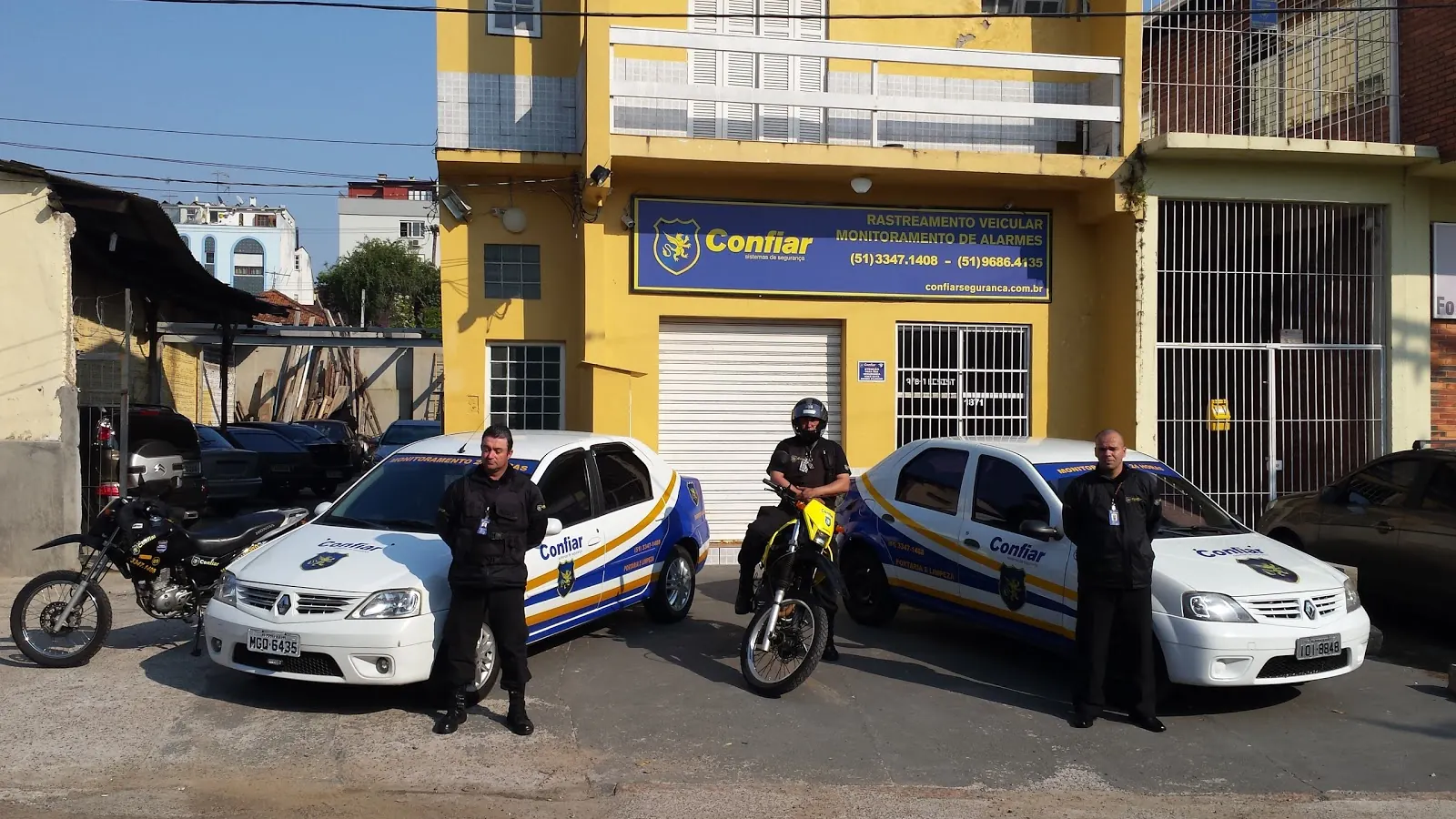 Equipe da Confiar com viaturas e motos em frente à sede